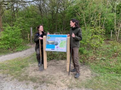 De twee boswachters zetten het bord gezamenlijk